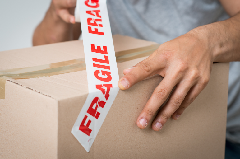 Man putting on fragile tag on the box