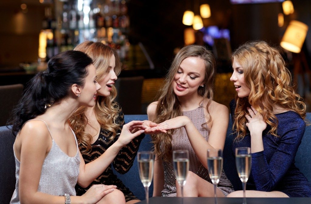 woman showing her engagement ring to her friends
