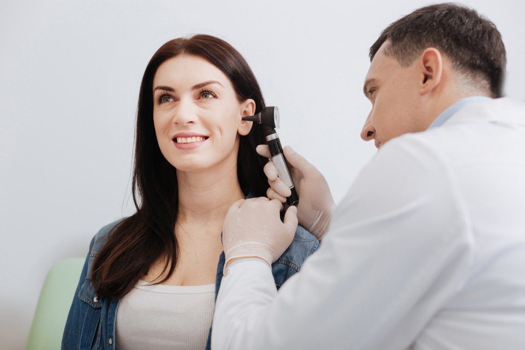 ENT doctor checking woman's ear