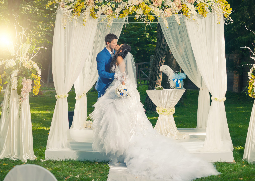 groom and bride kissing inside wedding marquee