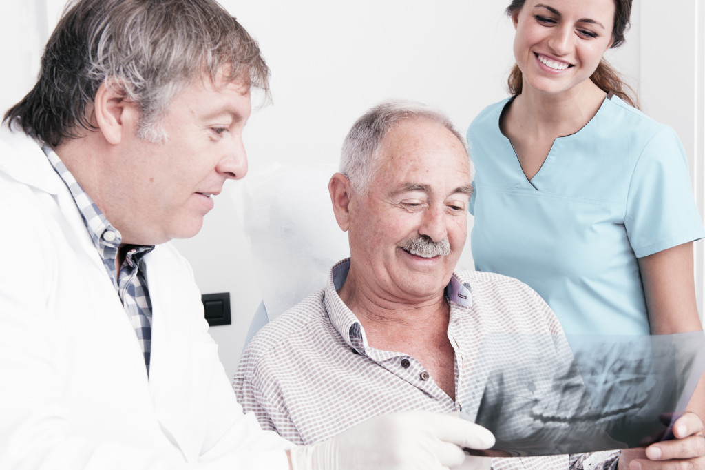 a senior man at a dentist looking at xray result