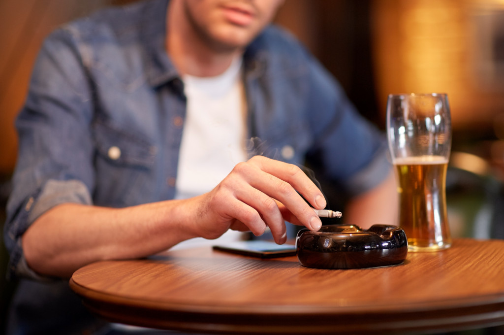 man smoking and drinking