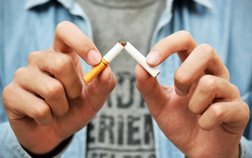 A man breaking a cigarette in to two, concept of quitting smoking