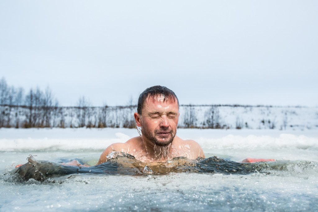 man in a winter lake for Ice therapy