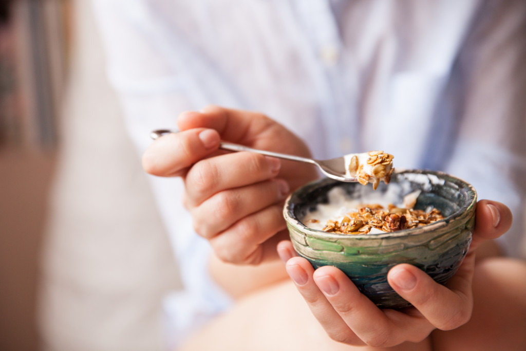 woman eating oats or granola with yogurt