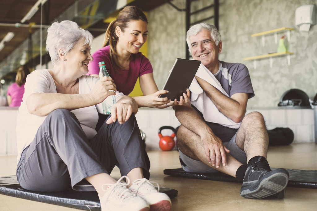 Young personal trainer showing a senior couple their current health status using a tablet.