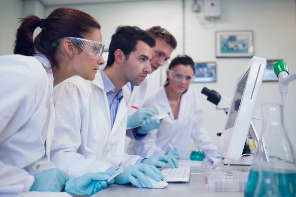 A group of medical researcher looking at a computer in a laboratory