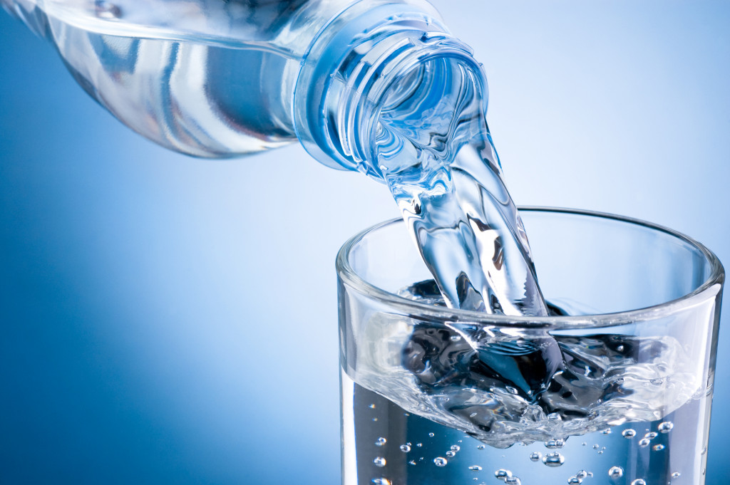 Water poured from a bottle to a glass