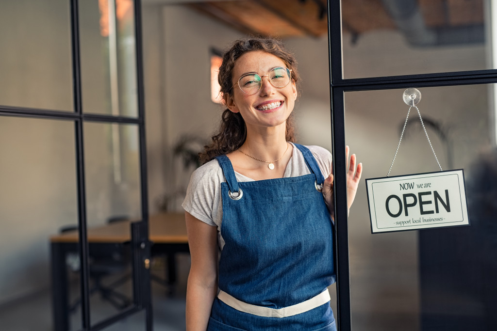 A restaurant owner at the entrance of her restaurant