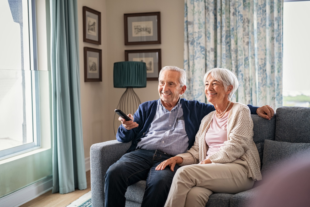 happy senior couple using remote