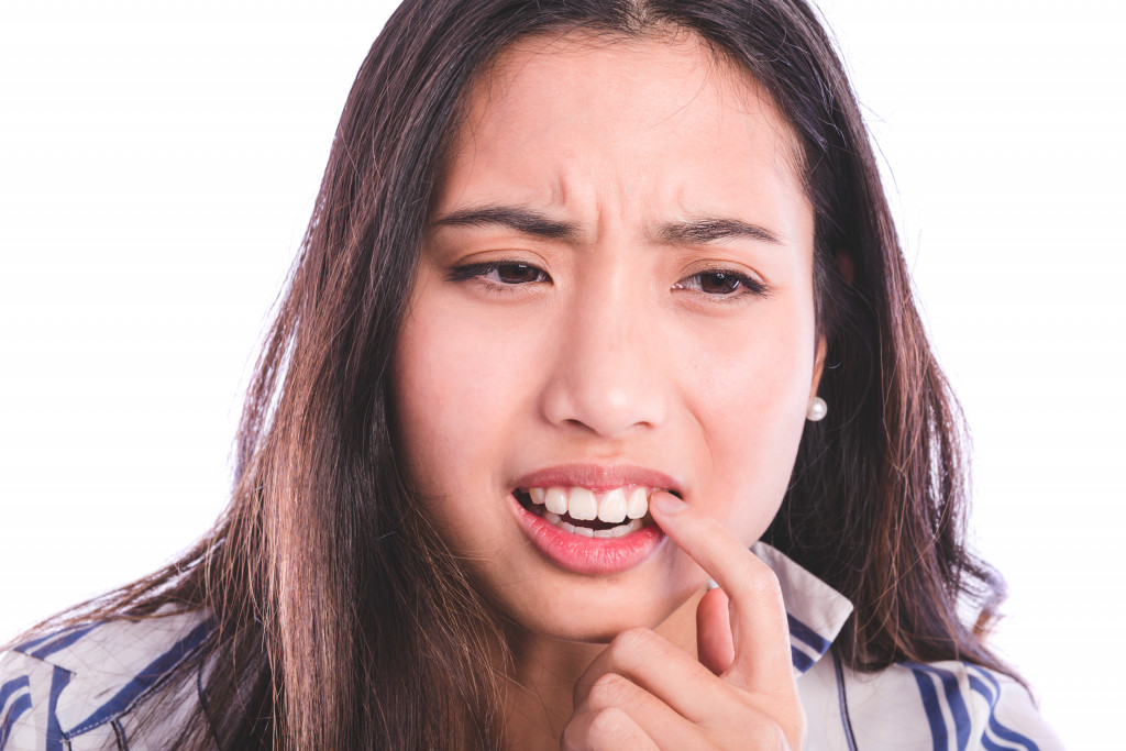 woman holding her teeth