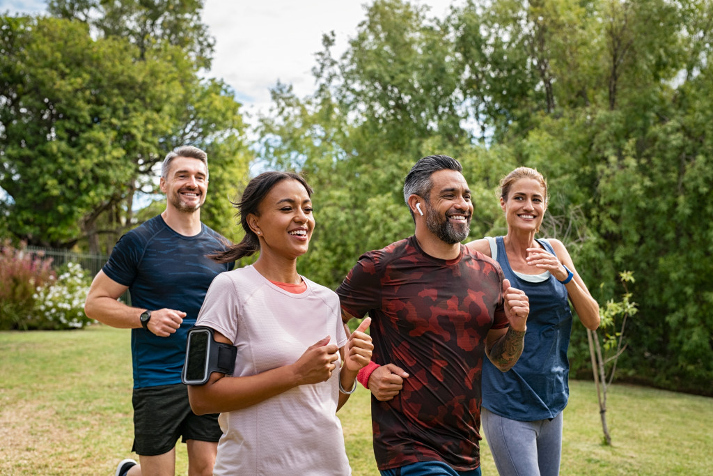 Happy mixed race couples running together. Mature friends running together outdoor.