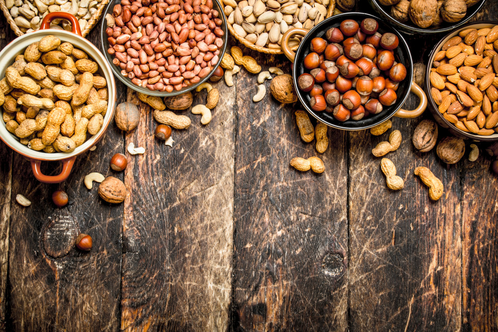 various nuts in bowls against wooden background