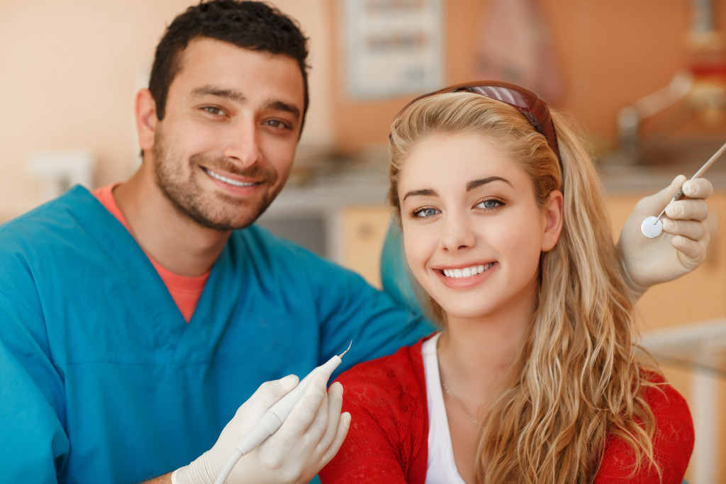 A woman and a dentist smiling to the camera