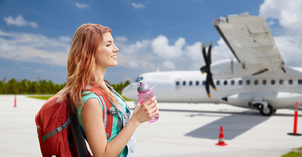 woman boarding a plane drinking water