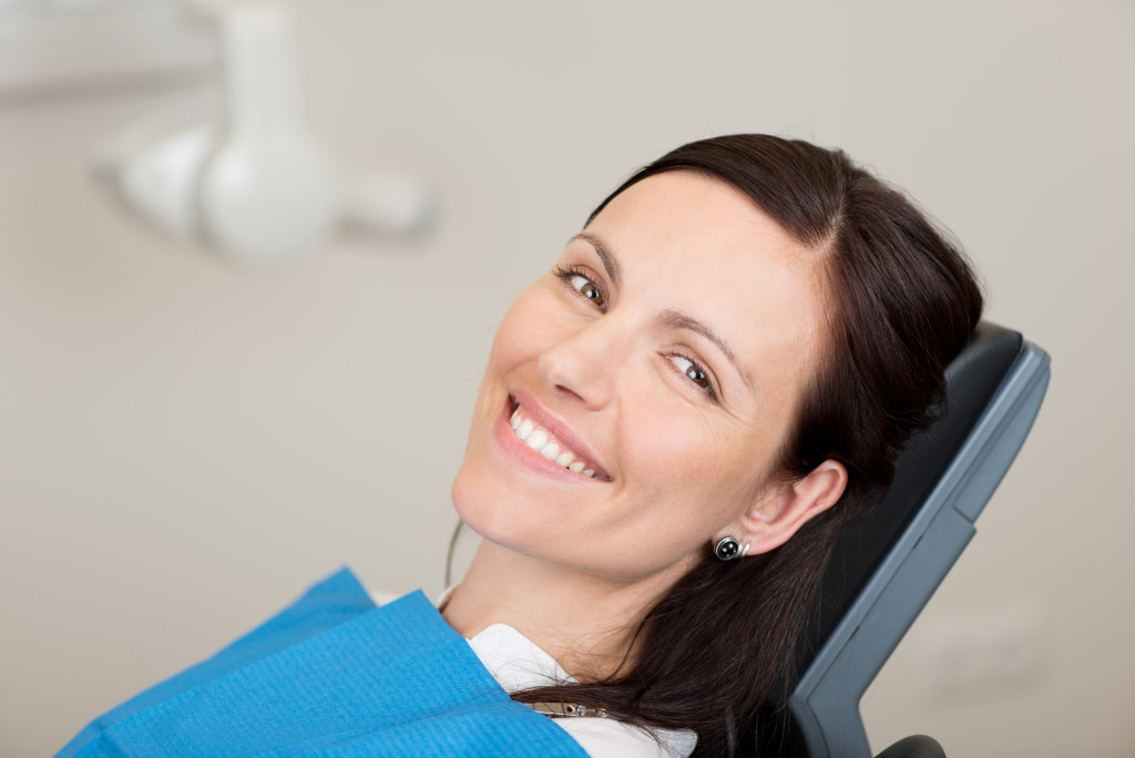 a smiling woman in a dentists chair