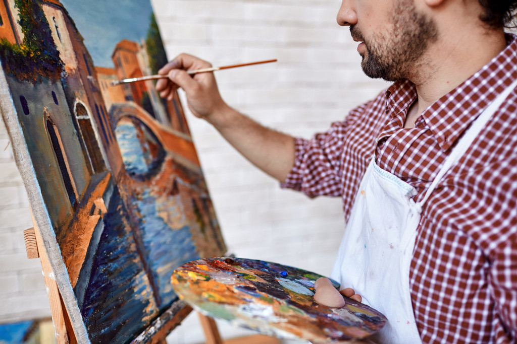 A man painting a landscape on canvas