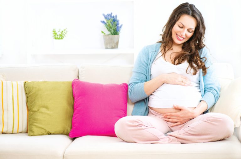 pregnant woman touching her baby bump