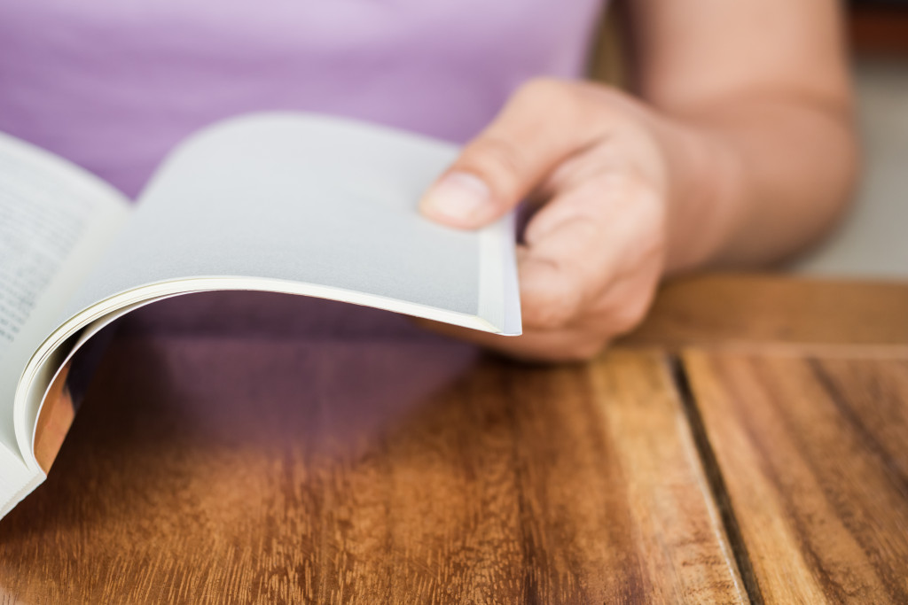 A person reading a book on the table