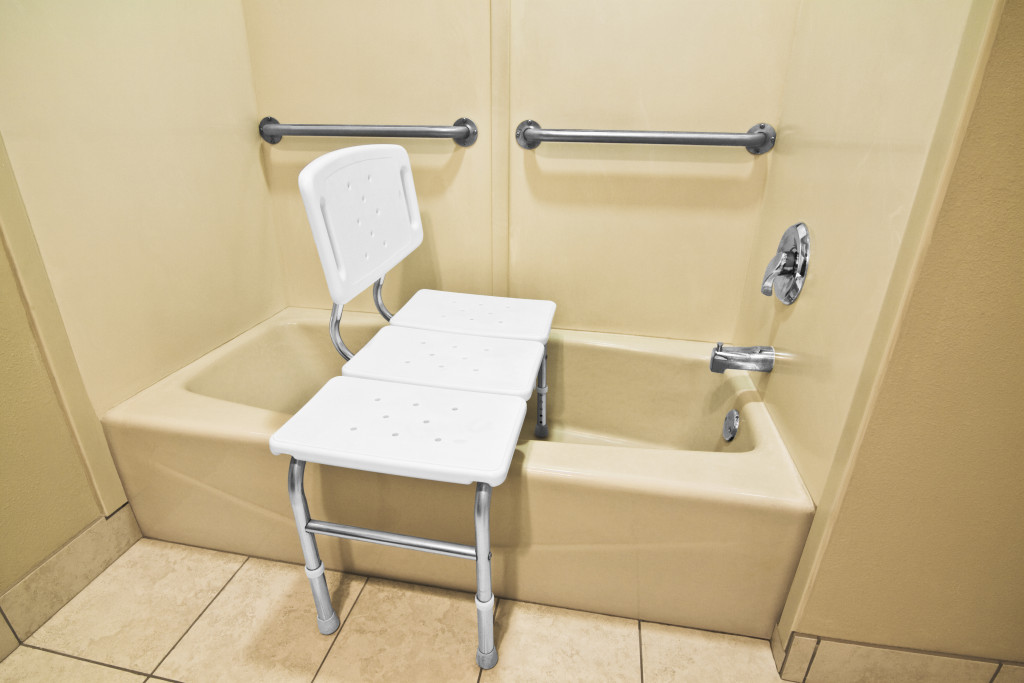 A bathroom with a bathing chair and grab bars