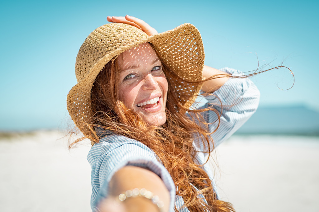 A woman wearing a straw hat on the beach