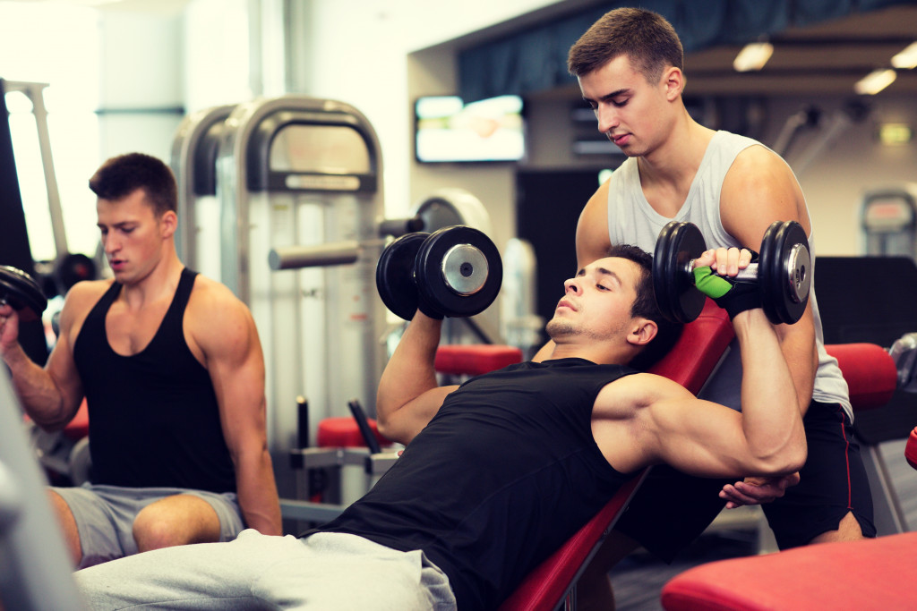 Three muscular men working out in the gym