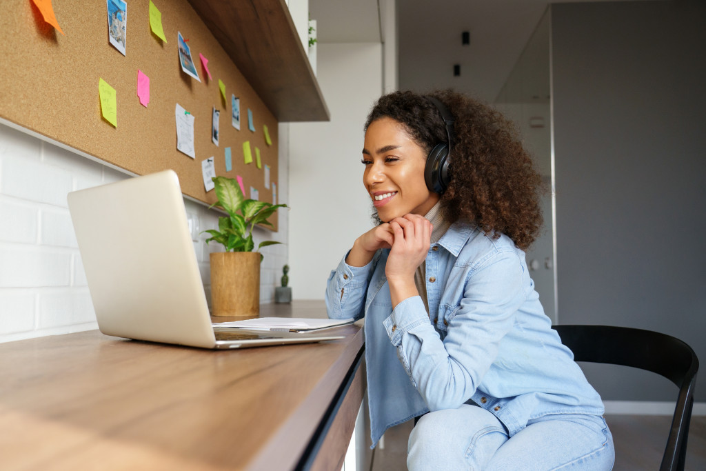 woman smiling while having a video call with family on laptop