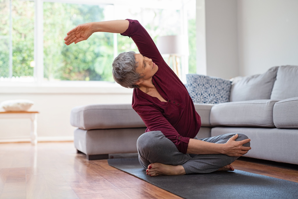 elderly woman performing yoga in the living room