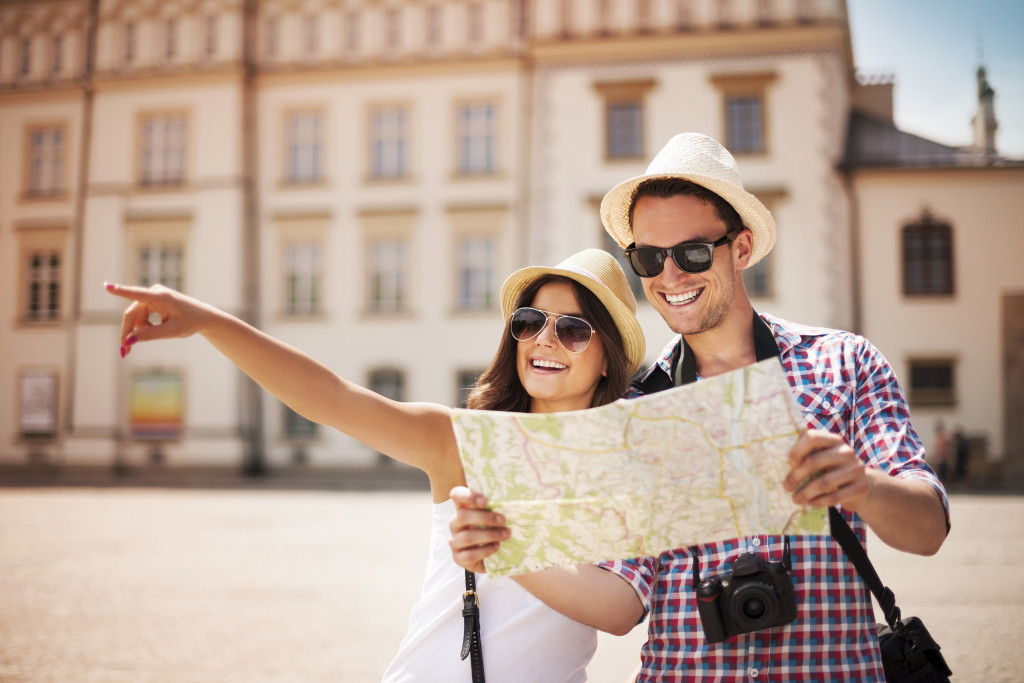 happy tourists sightseeing with map