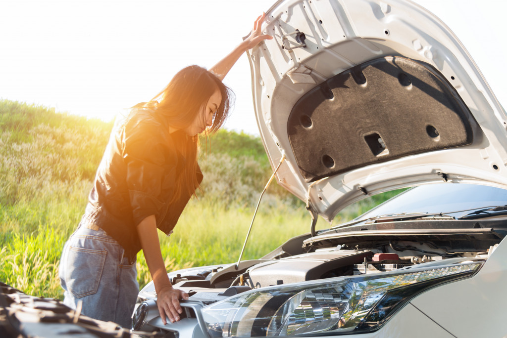 looking at the car engine at the side of the road