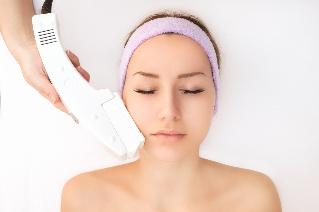 woman with eyes closed having laser skin procedure