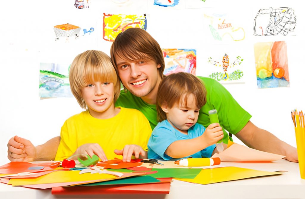 father and his two sons doing an art project