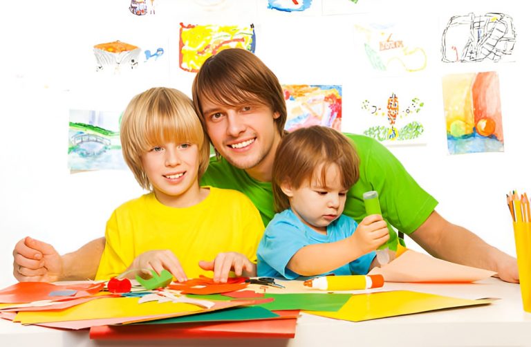 father and his two sons doing an art project